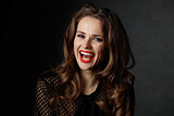 Portrait of smiling woman with long wavy brown hair and red lips