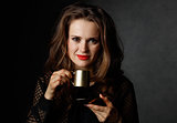 Portrait of woman with wavy brown hair holding cup of coffee