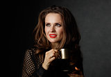 Woman with cup of coffee looking on copy space, dark background
