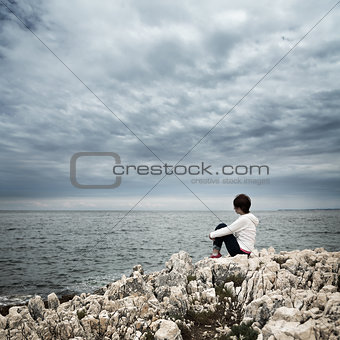 Lonely Woman Sitting at Stormy Sea