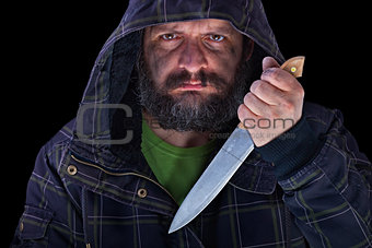 Hooded frightening man with dirty face and big knife
