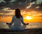 Woman Practicing Yoga by the Sea at Sunset