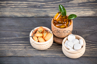 Various alternative and homeopatic pills in wooden containers