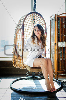girl sitting in the studio on a swing