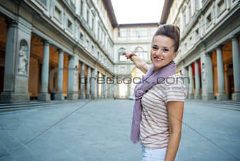 Woman tourist pointing on Uffizi Gallery in Florence, Italy
