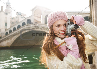 Woman tourist taking photos with retro photo camera in Venice