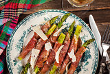 Green asparagus wrapped in parma ham on plate