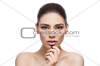 Beautiful girl applying pink lipstick