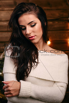 Portrait of gorgeous woman at home wooden background and lights on the wall