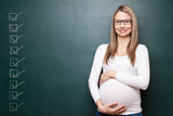 Pregnant woman and a blackboard with copyspace