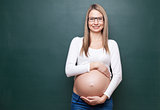 Pregnant woman and a blackboard with copyspace