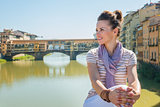 Happy tourist sitting on the bridge overlooking Ponte Vecchio