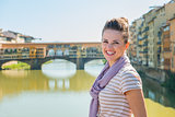Smiling tourist standing on the bridge overlooking Ponte Vecchio