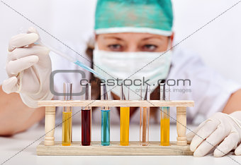 Woman experimenting with various liquids in test-tubes