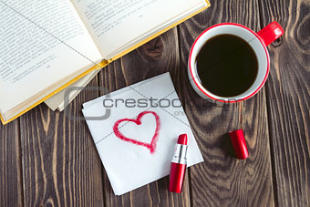 Mug of coffee books and red heart on the napkin on the wooden table