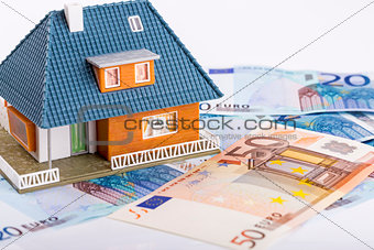 miniature house model on euro money banknotes