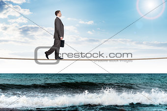 Businessman walking rope