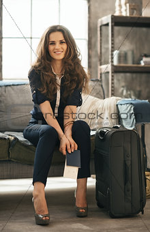 Woman with luggage in loft apartment waiting for departure
