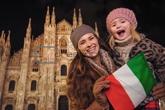 Mother and daughter showing Italian flag near Duomo in Milan