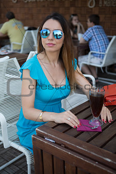 young woman in a blue summer dress at the bar