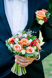 Groom holds a wedding flowers bouquet