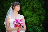 bride with a bouquet of roses in the park