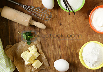 Ingredients for pastry - butter, milk, eggs, flour and vanilla sugar on a wooden background