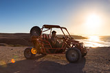 Man driving quadbike in sunset.