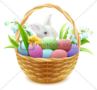 Wicker basket with Easter eggs, flowers and bunny