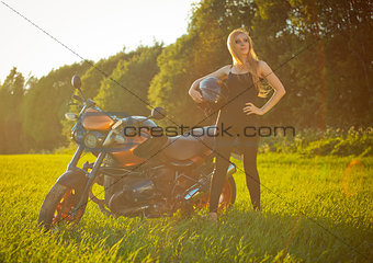 Beautiful girl with a motorcycle in the sun