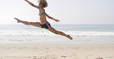 Happy Young Woman Jumping On The Beach