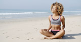 Woman Sitting On The Beach In Lotus Pose