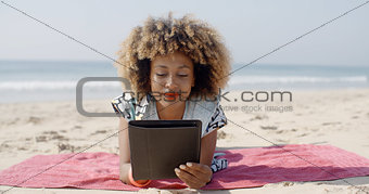 Woman Uses A Tablet On The Beach