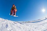 Snowboarder jumping against blue sky