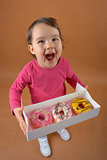 Little girl with different types of donuts