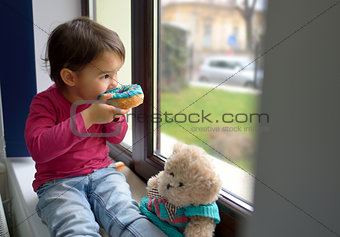 little girl eating  donuts