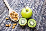 Fresh kiwi, apples and almonds on wooden background. Concept of healthy lifestyle