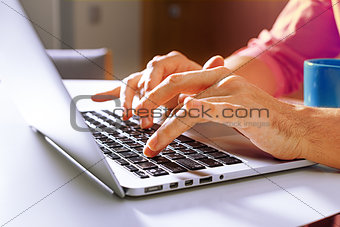 Cropped shot of a man's hands typing