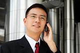 Young asian executive talking on handphone