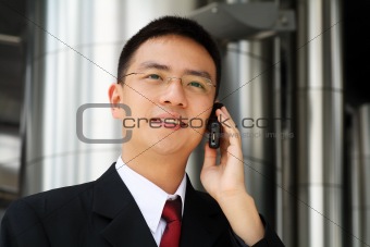 Young asian executive talking on handphone