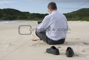 Businessman with laptop on the beach