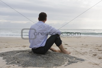 Businessman sitting on the beach