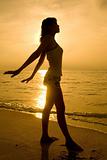 woman silhouette on the sunset beach