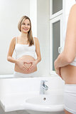 Pregnant woman in bathroom mirror