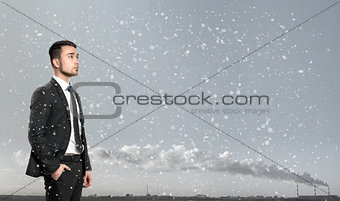 Young man in business suit, standing front of industrial city landscape sunrise. Business, leadership and success concept