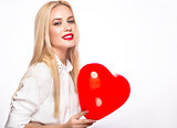 Portrait of Beautiful blond woman with bright makeup and red heart in hand. valentines day