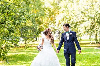 Wedding couple holding hands outdoors