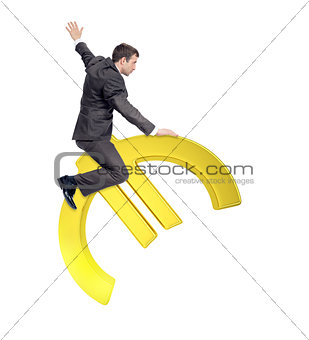 Businessman riding golden euro sign