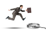 Running businessman with bear trap