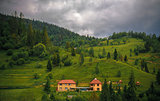 wooded Carpathians slopes with houses in center of the frame